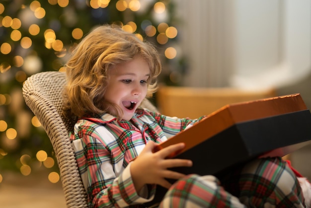 Enfant garçon près de sapin de noël à la maison joie et bonheur moments d'enfance