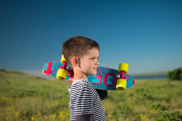 Enfant garçon avec skateboard dans la nature