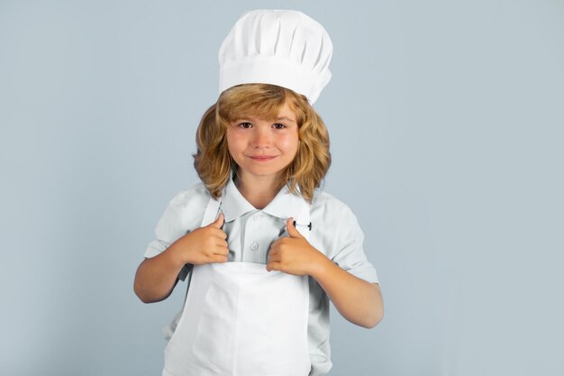 Enfant garçon en toque et tablier de cuisine préparation de repas chef drôle de tête