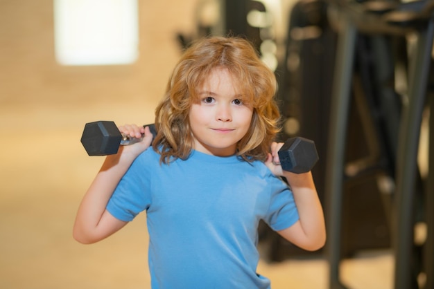 Photo enfant garçon travaillant avec des haltères sport et formation des enfants