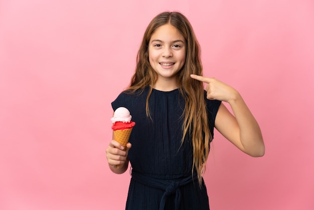 Enfant avec une glace au cornet sur fond rose isolé donnant un geste du pouce vers le haut