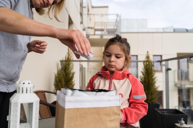 Photo une enfant avec une grand-mère semant des plantes sur le balcon au printemps concept de jardinage urbain