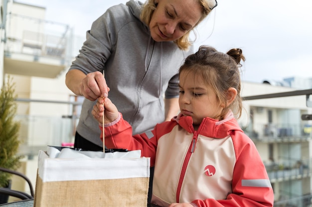 Photo une enfant avec une grand-mère semant des plantes sur le balcon au printemps concept de jardinage urbain