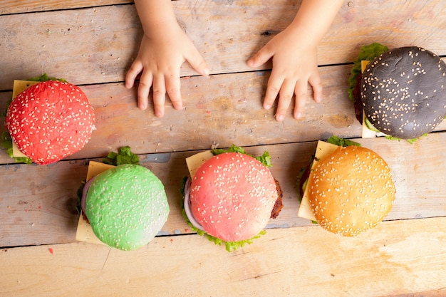 Enfant avec des hamburgers colorés