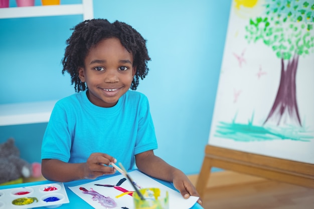 Photo enfant heureux, appréciant la peinture d'artisanat