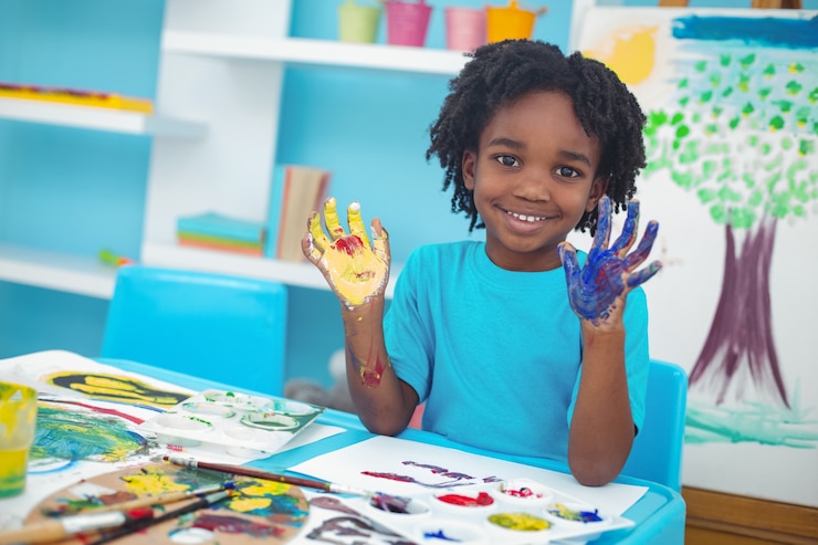 Photo enfant heureux, appréciant la peinture avec ses mains