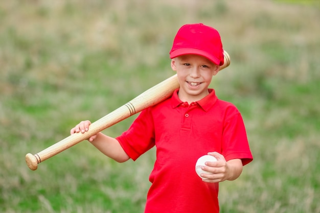 Un enfant heureux avec une batte de baseball sur le concept de la nature dans le parc