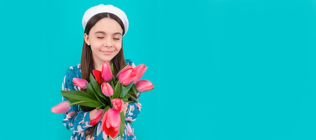 Un enfant heureux en béret sent les tulipes mères ou les enfants de la fête des femmes tiennent des fleurs pour la bannière du 8 mars