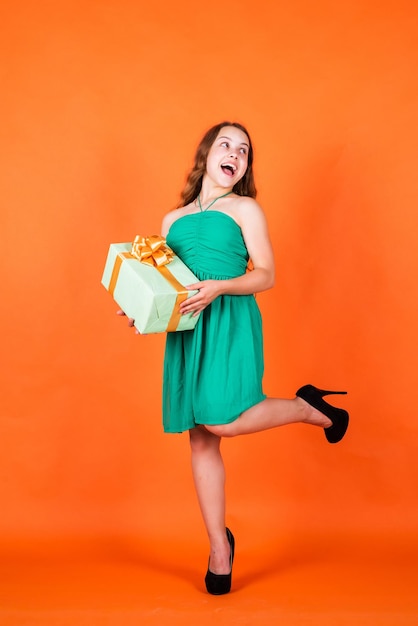 Enfant heureux avec boîte-cadeau sur fond orange, cyber lundi.