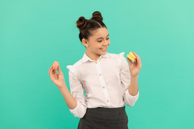 Enfant heureux avec boulangerie dessert. un enfant tient un macaron français. biscuit macaron. confiserie. gâteaux français sucrés. soins dentaires pour adolescentes. dent sucrée. délicieux. biscuits de pâtisserie.