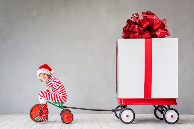 Enfant heureux avec cadeau de Noël. Enfant s'amusant à la maison