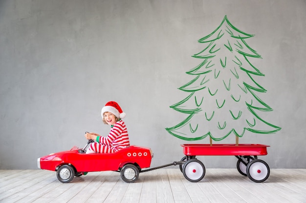 Enfant heureux avec cadeau de Noël. Enfant s'amusant à la maison