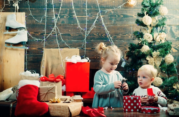 Enfant heureux avec un cadeau de Noël sur fond de bois concept d'histoire de Noël Petits enfants mignons célébrant Noël Noël enfants concept de bonheur kiddy