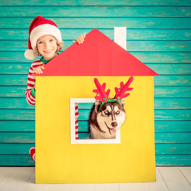 enfant heureux et chien la veille de noël enfant et animal de compagnie vêtus d'un chapeau de père noël