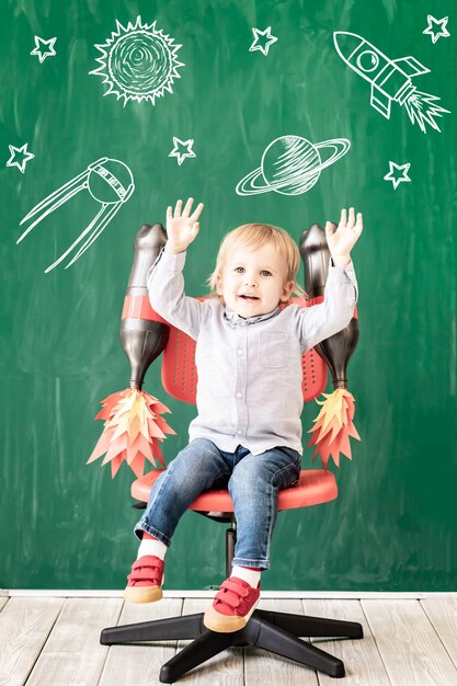 Enfant heureux en classe. Enfant drôle contre le tableau. Retour à l'école. Notion d'éducation