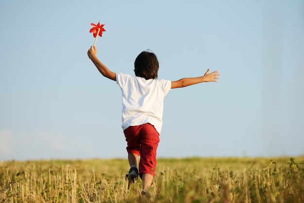 Enfant heureux courant sur le beau champ