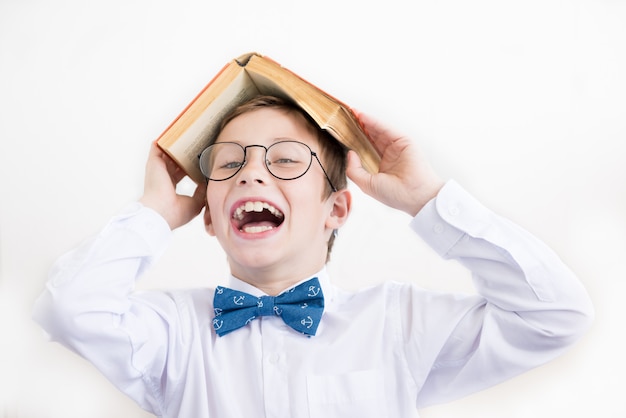 Enfant heureux dans des verres sous le toit fait de livre