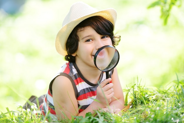 Enfant heureux, explorer la nature avec une loupe