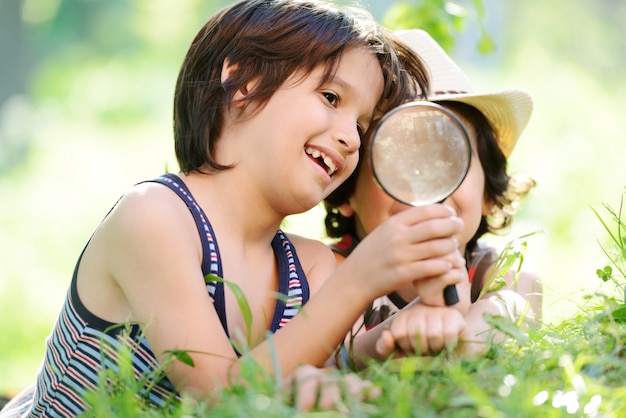 Enfant heureux, explorer la nature avec une loupe