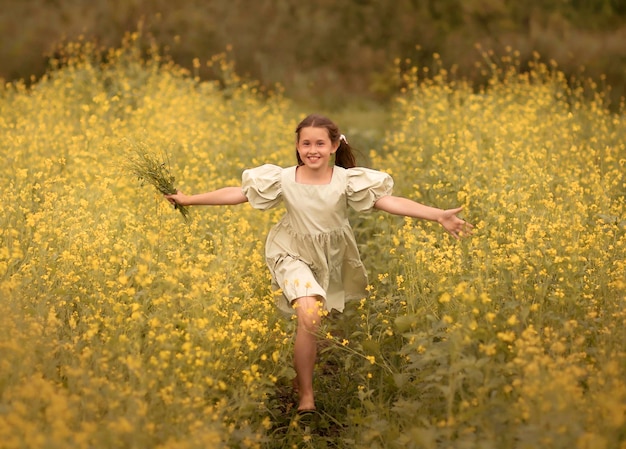 enfant heureux fille courant avec un bouquet de fleurs sur un champ jaune fleuri