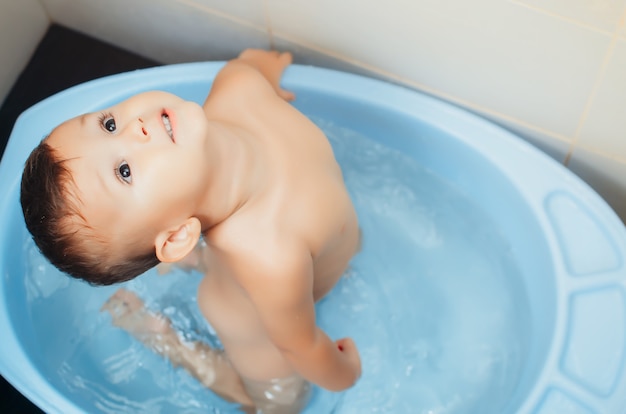 Enfant heureux, un garçon se baigne dans un bain très mignon