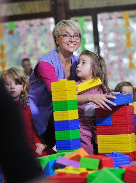 enfant heureux groupe d'enfants s'amuser et jouer à la maternelle concept d'éducation préscolaire intérieure avec enseignant