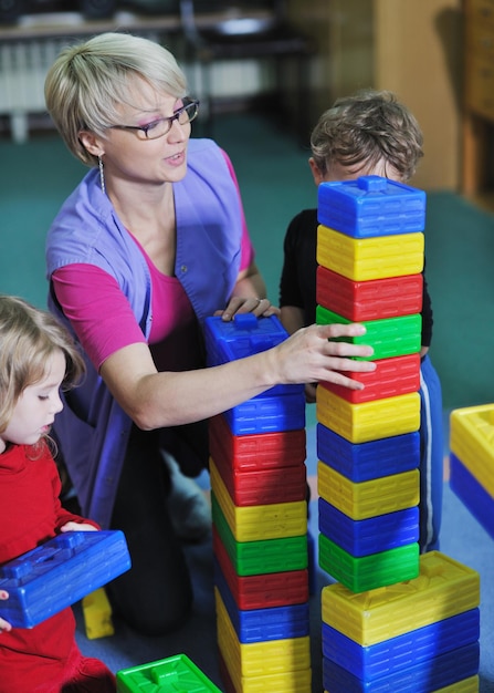 enfant heureux groupe d'enfants s'amuser et jouer à la maternelle concept d'éducation préscolaire intérieure avec enseignant