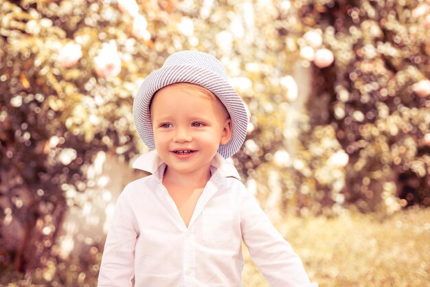 A un enfant heureux et insouciant a une joie d'été un garçon heureux debout dans l'herbe au jour d'été ensoleillé