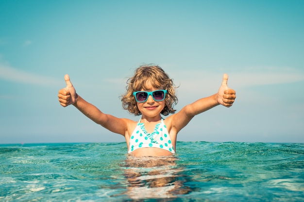 enfant heureux jouant dans la mer