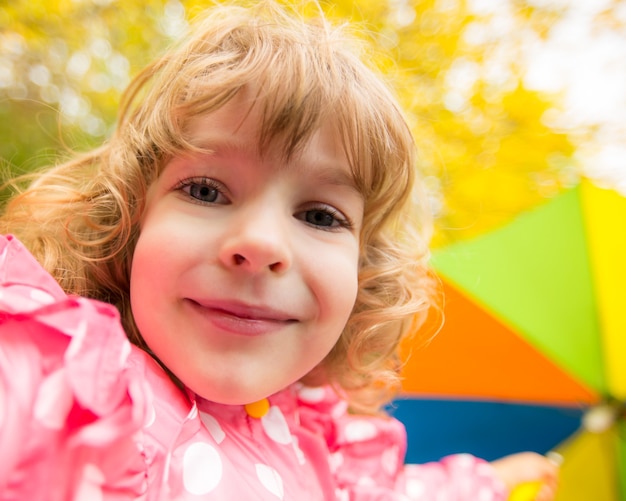 Enfant heureux jouant dehors en parc d'automne