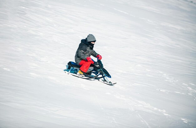 Un enfant heureux jouant sur une promenade hivernale dans la nature. Un enfant profitant d'un trajet en traîneau dans la neige.