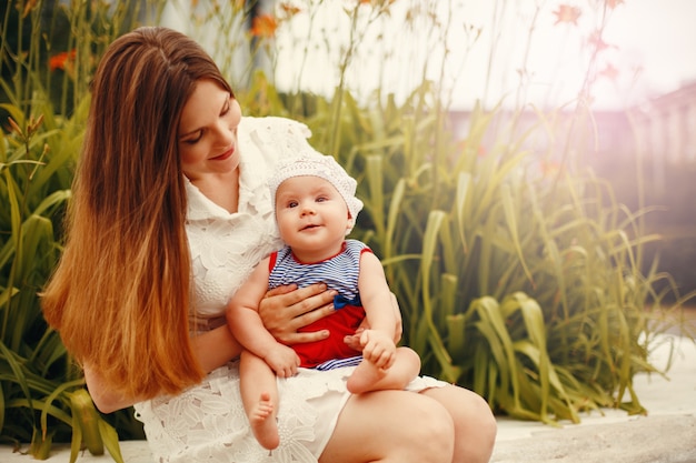 Enfant heureux mignon assis sur les genoux de la mère aimante