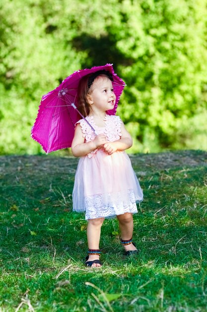 Enfant heureux avec un parapluie dans le parc sur la nature