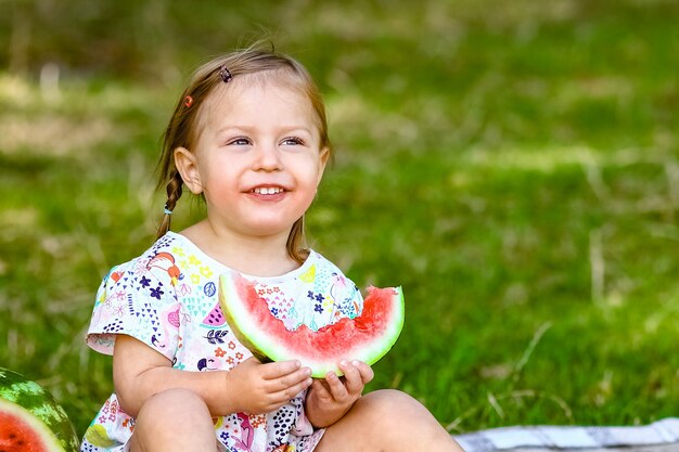 Enfant heureux avec pastèque sur la nature dans le parc