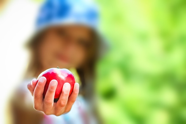 Enfant heureux avec pomme sur la nature dans le fond du jardin