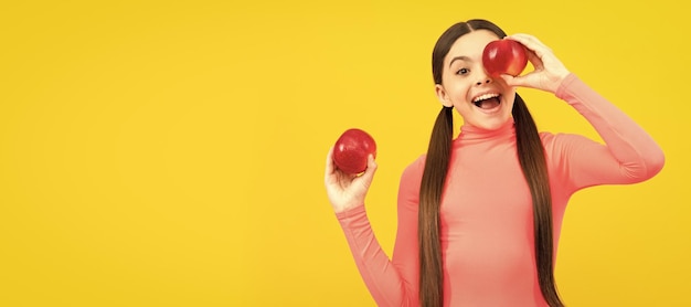 Enfant heureux avec pomme rouge sur fond jaune vitamines Portrait de fille enfant avec affiche horizontale de pomme En-tête de bannière avec espace de copie