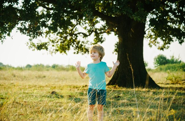 Photo un enfant heureux sur le pré en été dans la nature un enfant qui s'amuse à la campagne