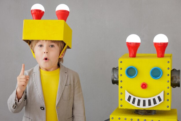 Enfant heureux avec robot. Enfant drôle jouant à la maison. Concept de technologie de réussite, de créativité et d'innovation