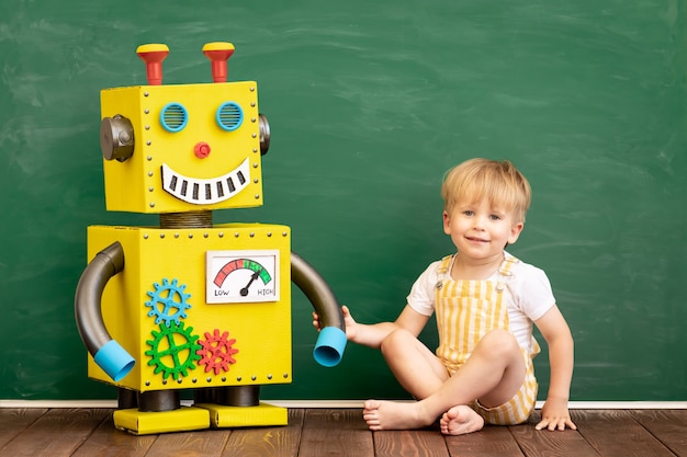 Enfant heureux avec robot jouet en classe préscolaire.