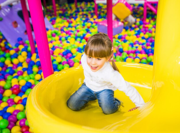 Enfant heureux s'amuser dans la salle de jeux