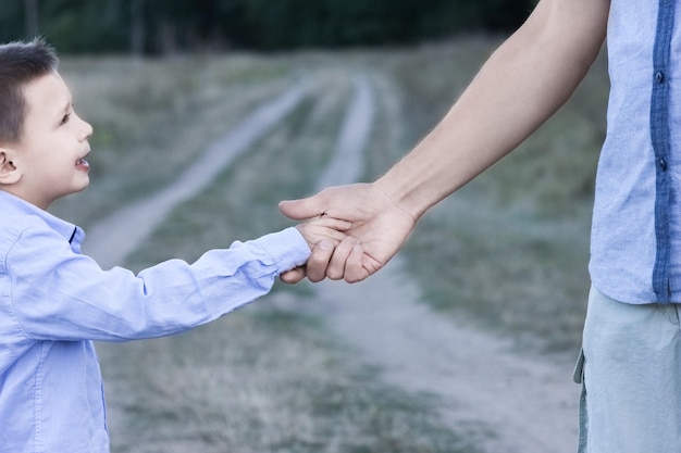 Un enfant heureux et ses parents en train de voyager dans le parc