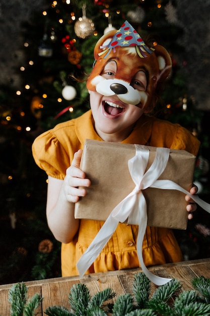 Enfant heureux sous le sapin de Noël avec un cadeau.