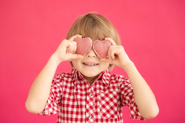 Enfant heureux tenant le coeur dans les mains