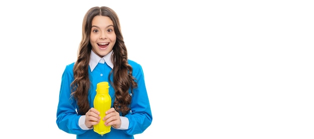 Un enfant heureux tient une bouteille jaune en plastique avec des produits laitiers liquides isolés sur du yaourt à boire blanc