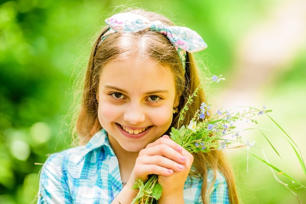 Un enfant heureux tient des fleurs sauvages Beauté naturelle Bonheur de l'enfance Vacances d'été Environnement vert Petite fille et bouquet de fleurs Fleurs sauvages Vacances de printemps Journée de la femme Pour toujours jeune et libre