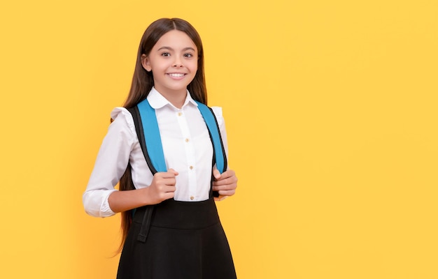 Un enfant heureux en uniforme scolaire porte un espace de copie de sac à dos à l'école