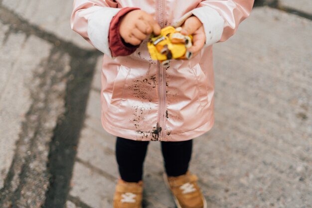 Un enfant avec un imperméable sale à l'extérieur