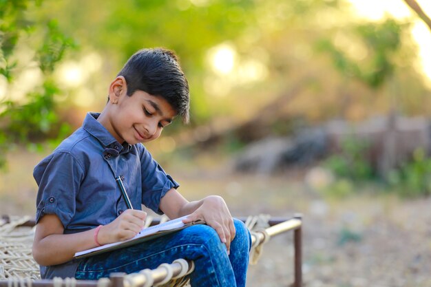 Enfant indien mignon fait ses devoirs à la maison