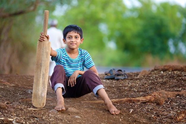 Enfant indien rural jouant au cricket