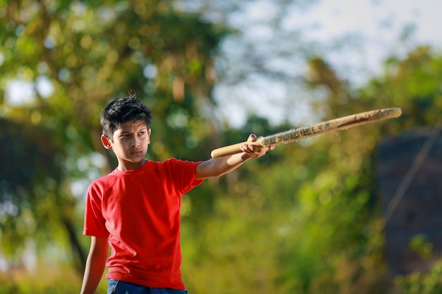 Enfant indien rural jouant au cricket